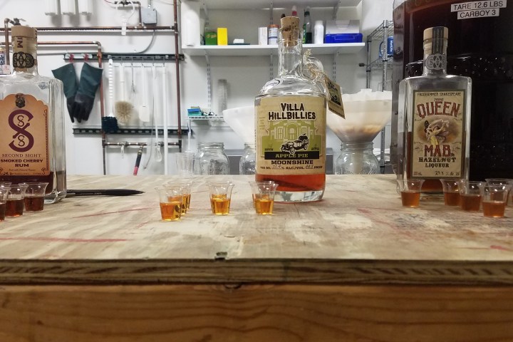 bottles of whiskey with shot glasses on counter
